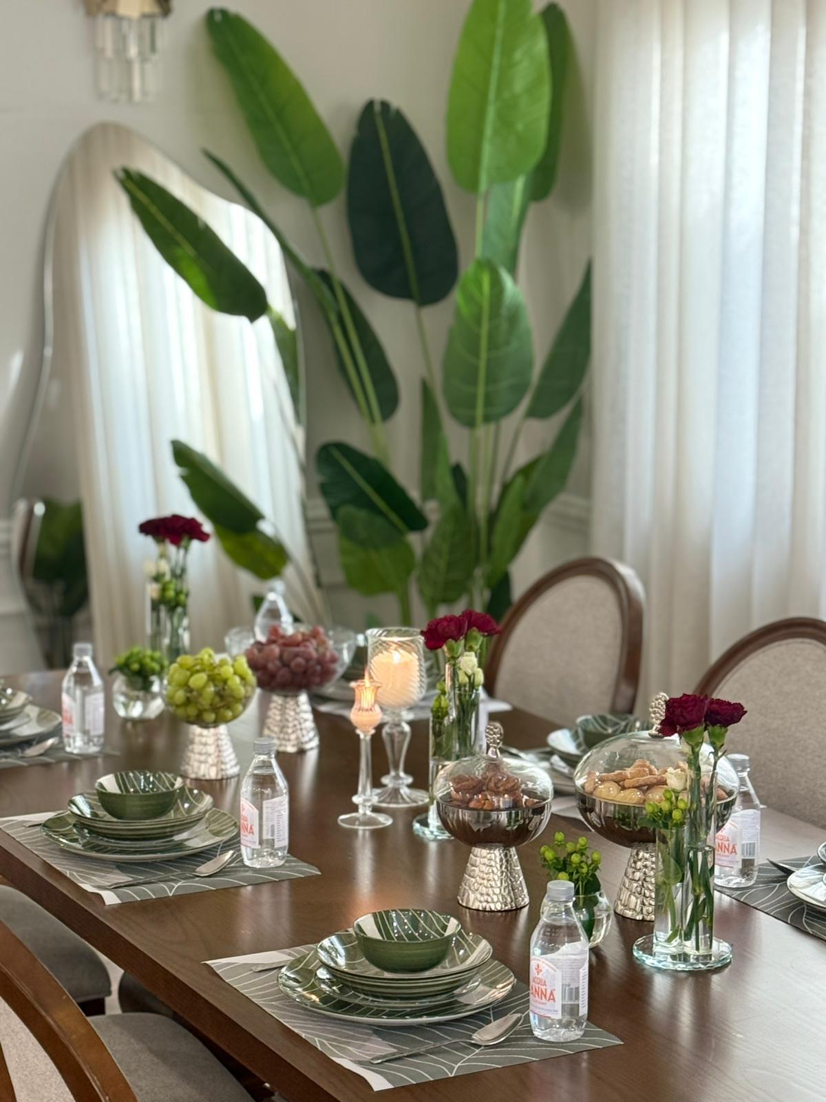 Elegant dining table styled with Rawda Collection porcelain — green Rayhan botanical design with crystal accents and fresh flowers